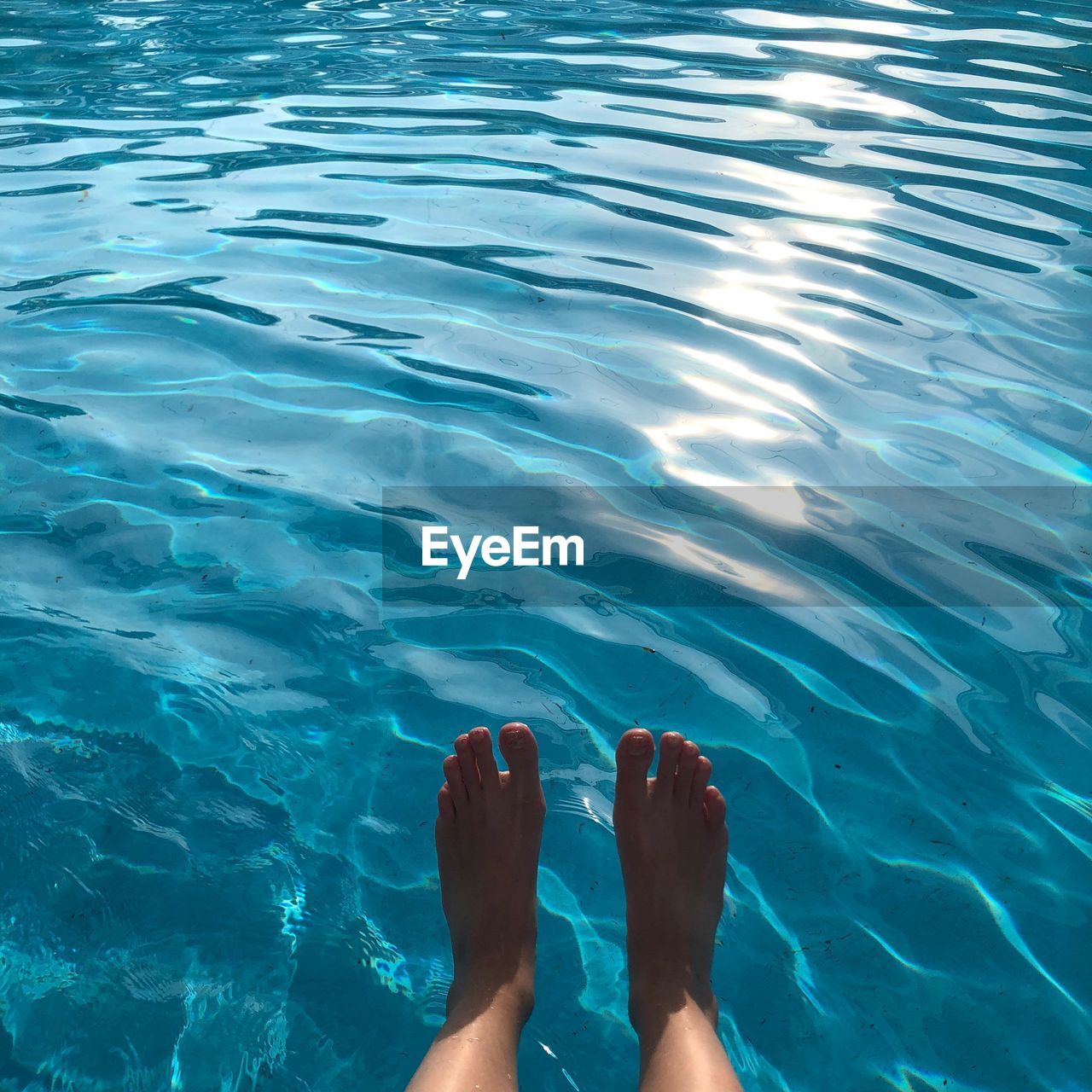 Low section of woman against swimming pool