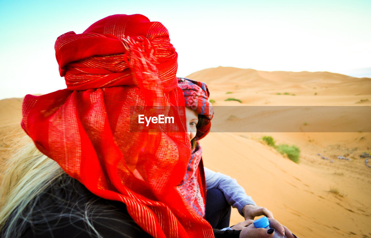 Women in desert against sky