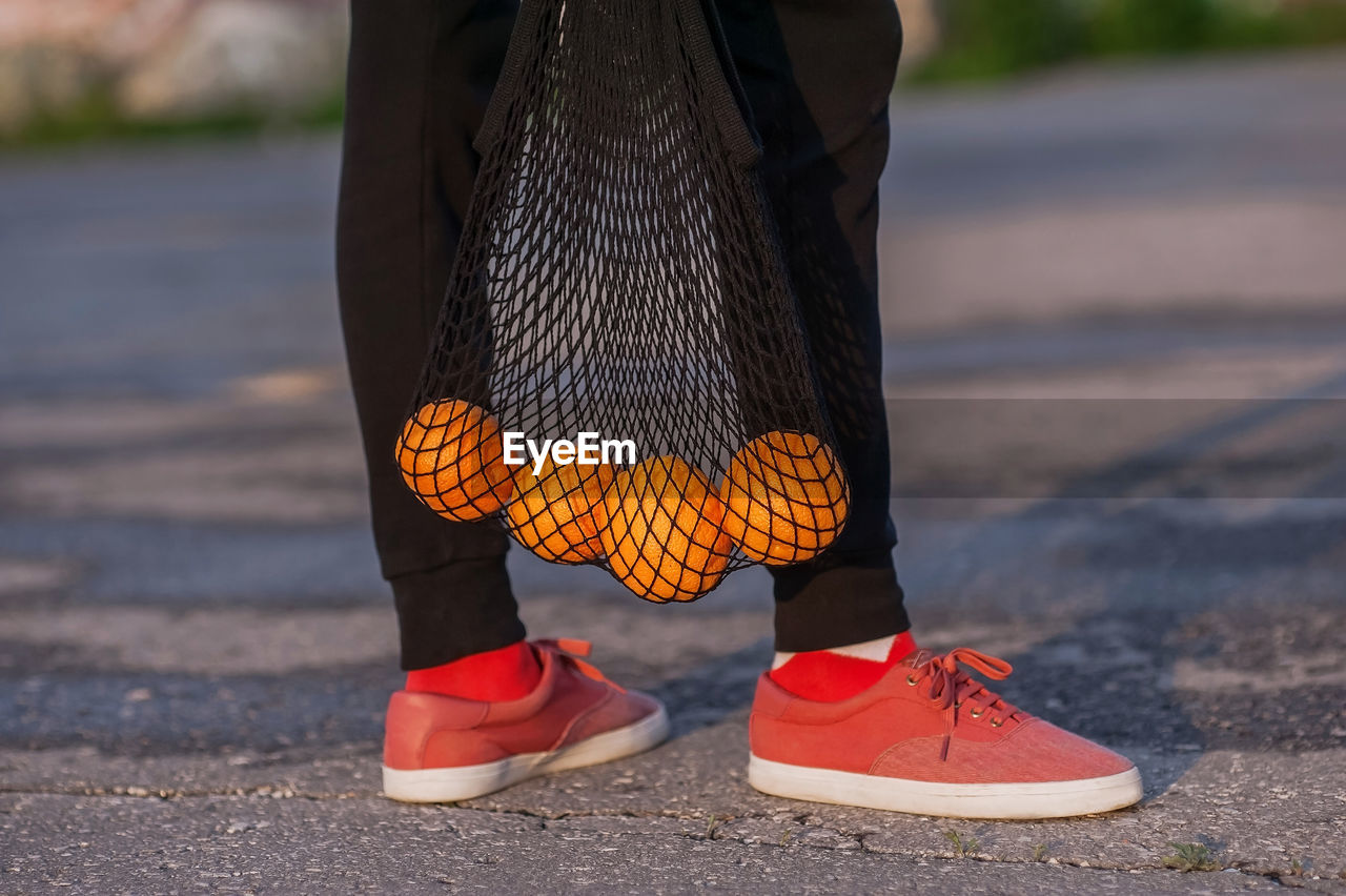 Low section of woman with oranges