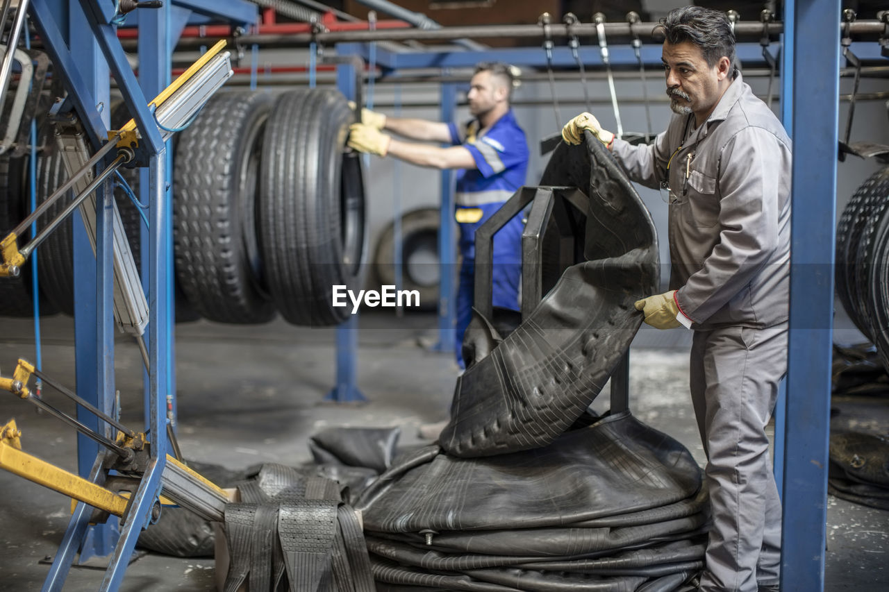 Two tire repairmen working in factory