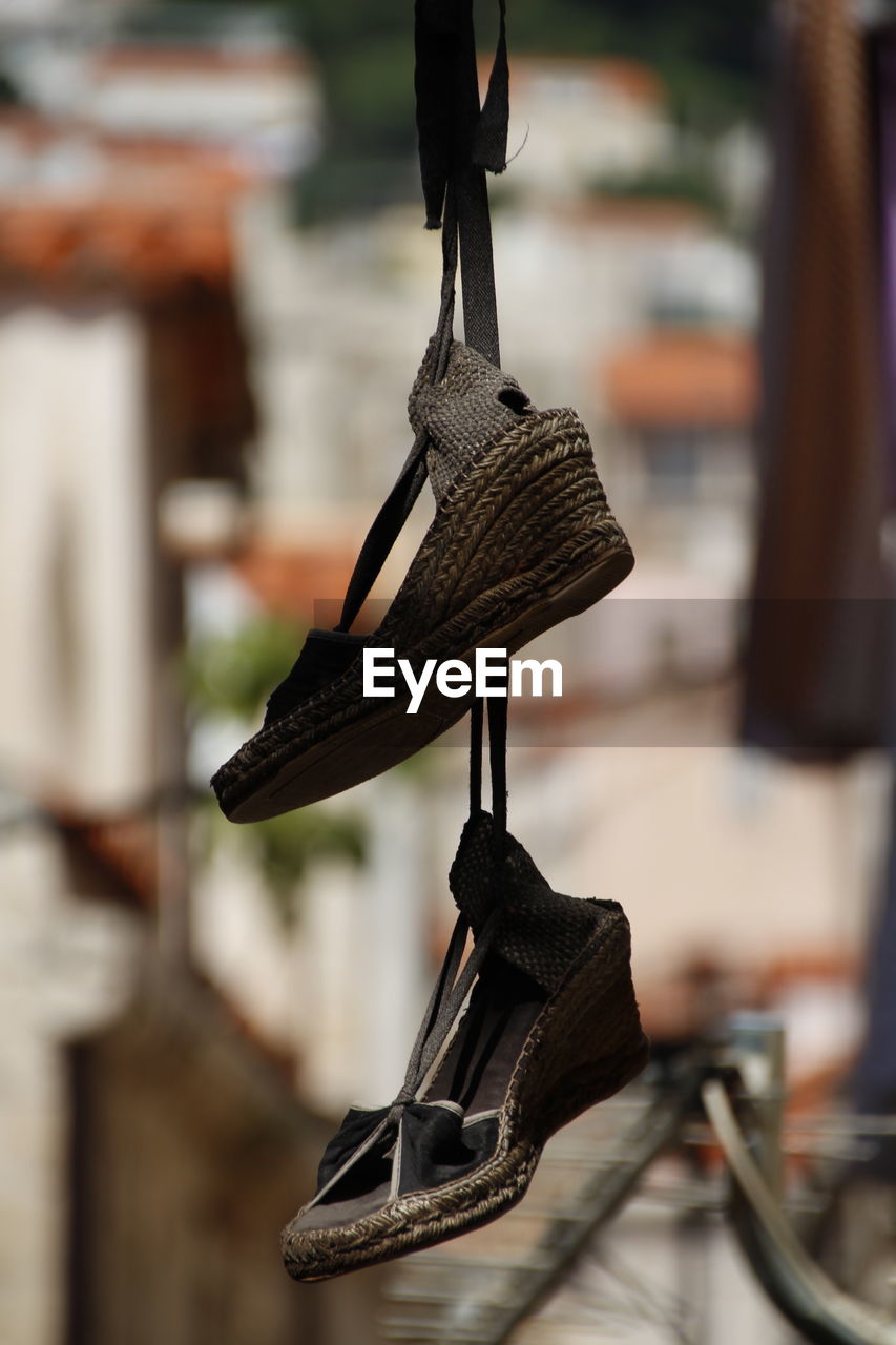 CLOSE-UP OF SHOES HANGING ON METAL IN RACK