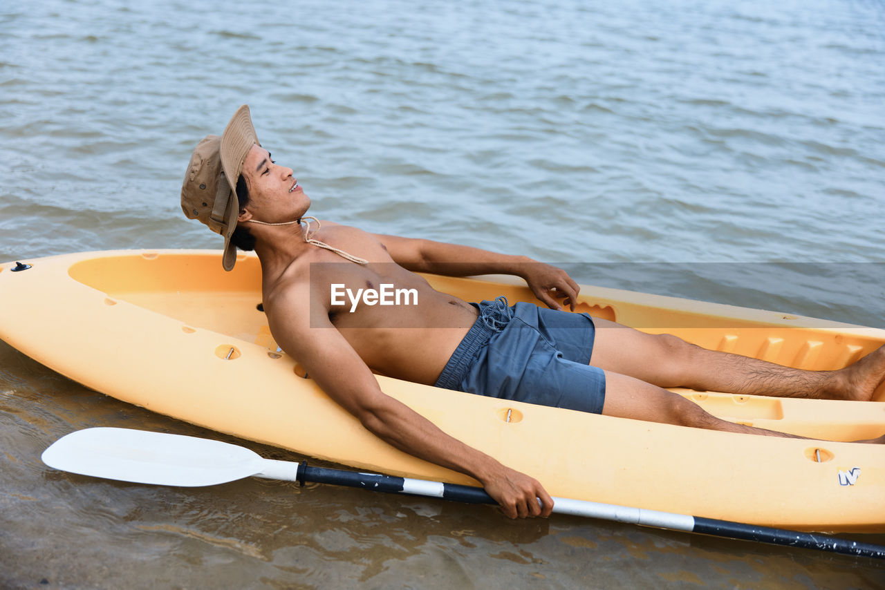 rear view of young woman in boat on sea