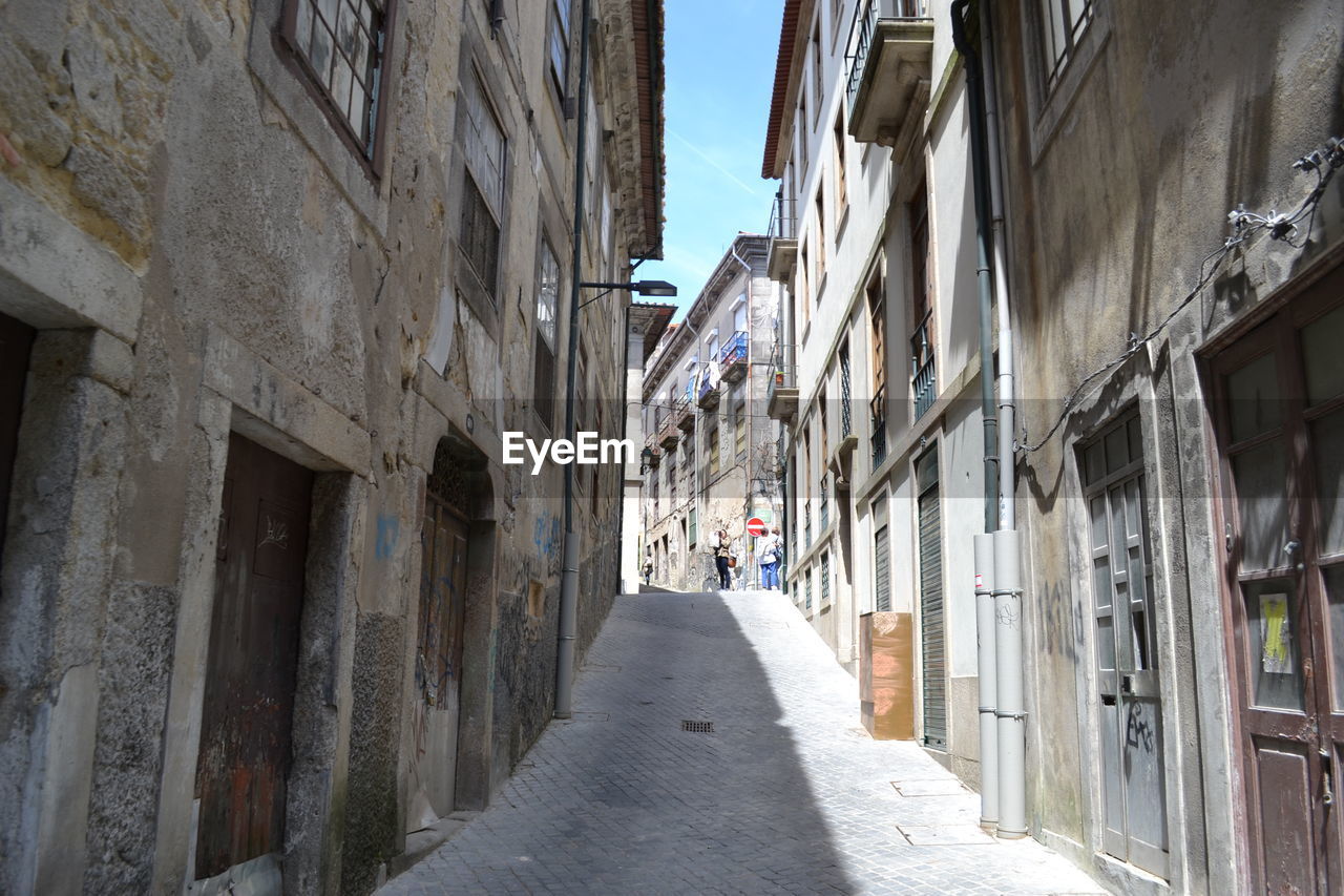 STREET AMIDST RESIDENTIAL BUILDINGS AGAINST SKY