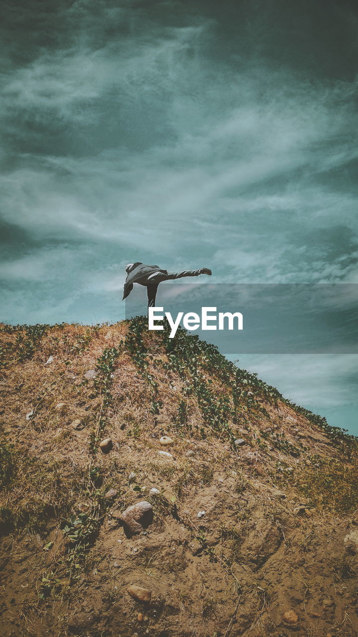 View of man standing on mountain against sky