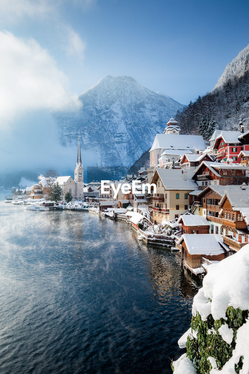 Scenic view of townscape by lake during winter