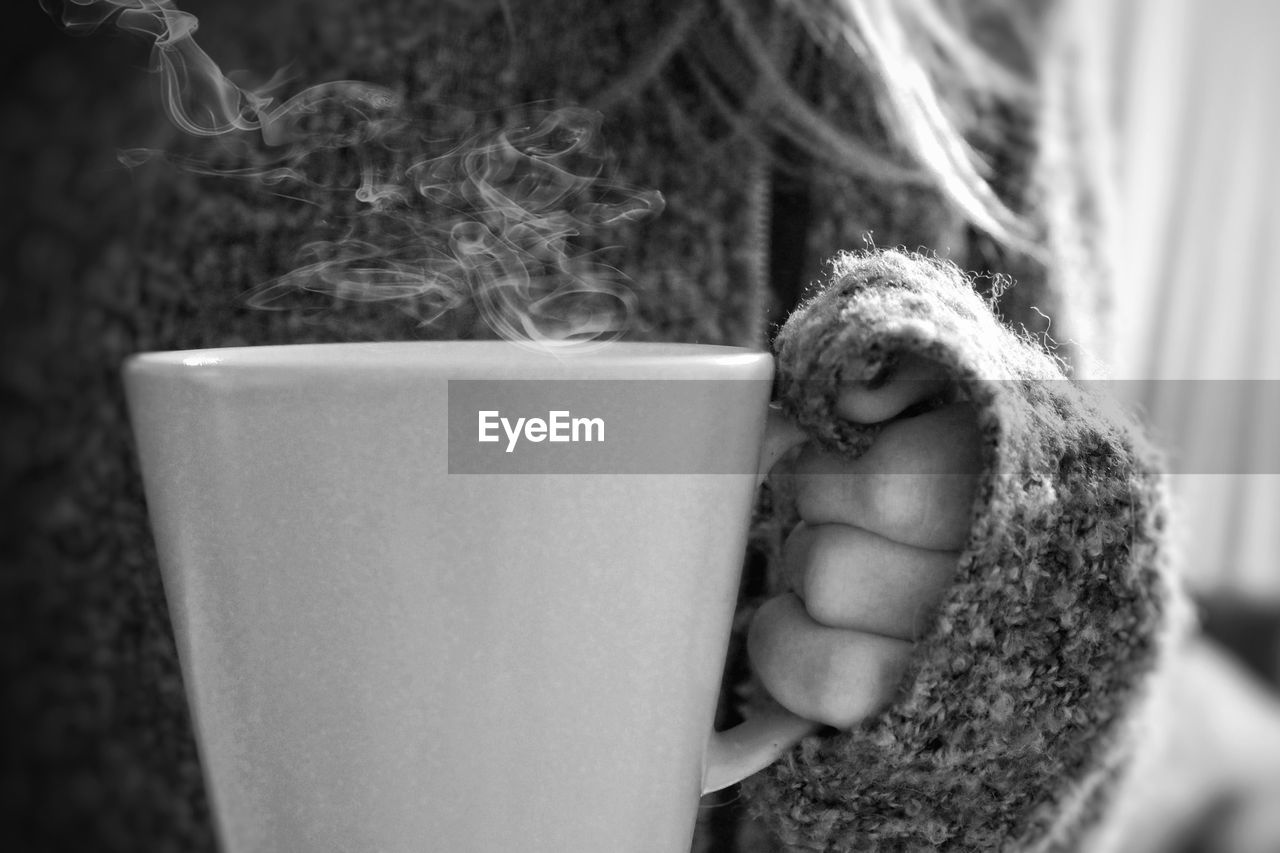 Cropped hand of woman holding coffee cup