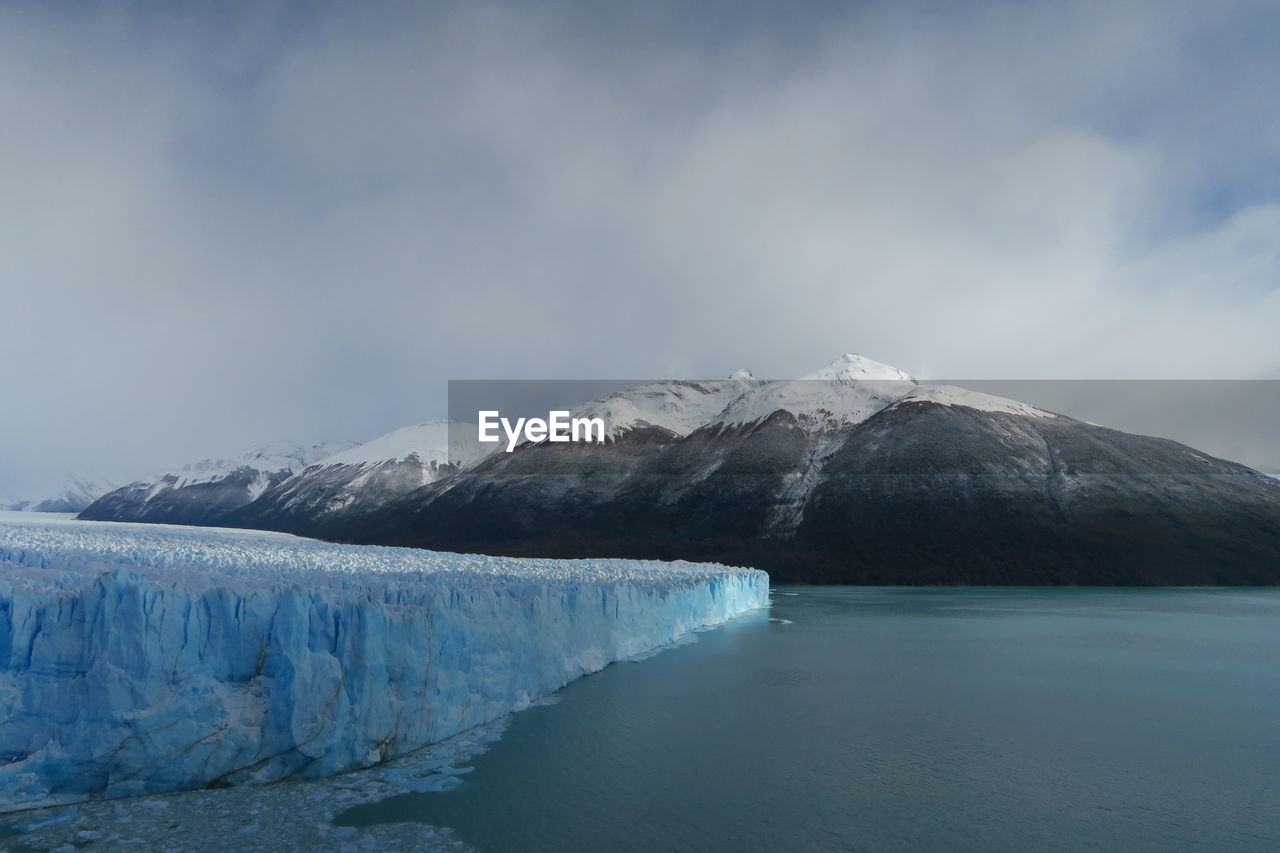 Scenic view of perito moreno glacier by lake against sky