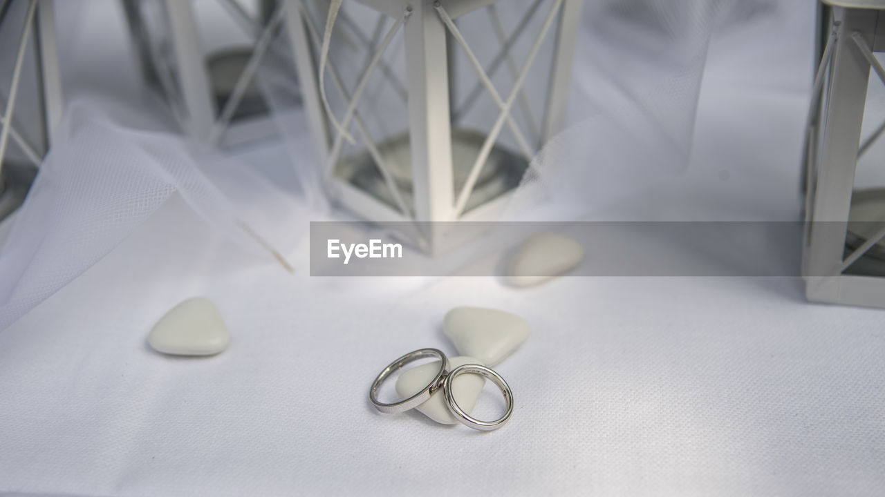 CLOSE-UP OF WEDDING RINGS ON BED