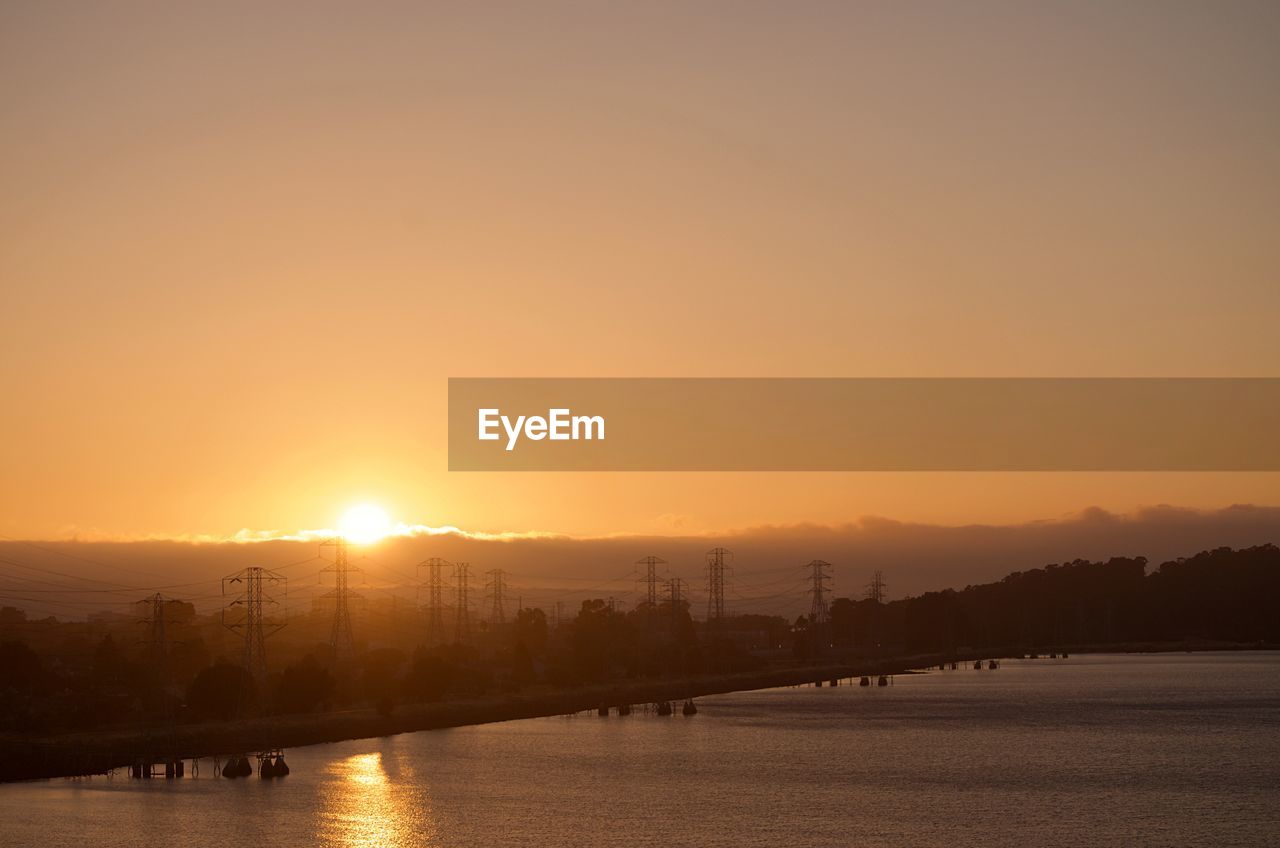 SCENIC VIEW OF RIVER AGAINST ORANGE SKY DURING SUNSET