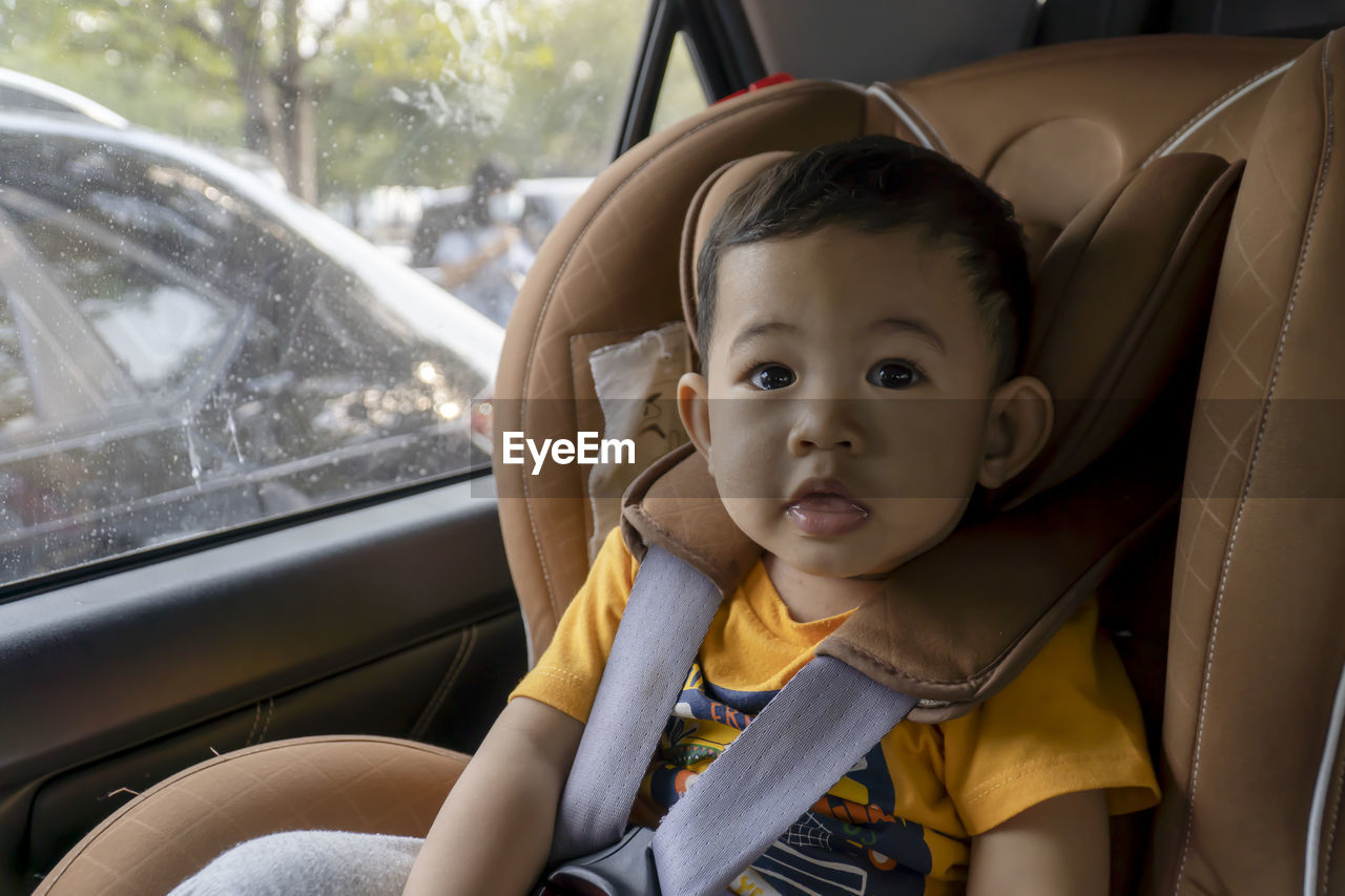 Close-up of little boy children on a car seat in the car.