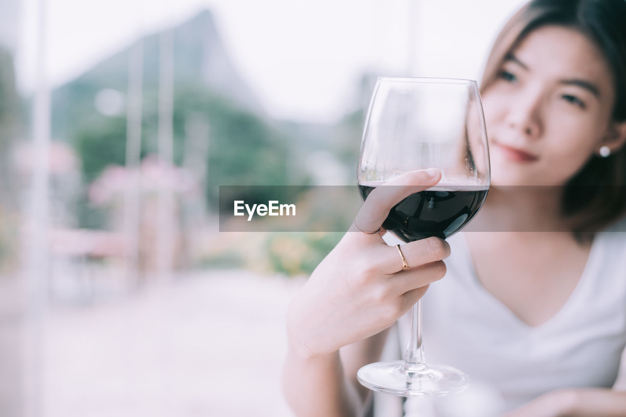 PORTRAIT OF WOMAN DRINKING GLASS