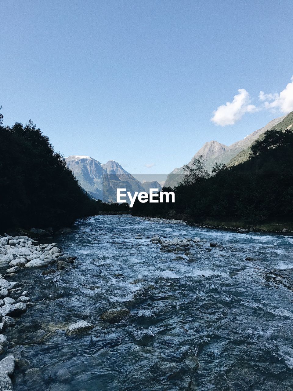 Scenic view of river and mountains against clear sky