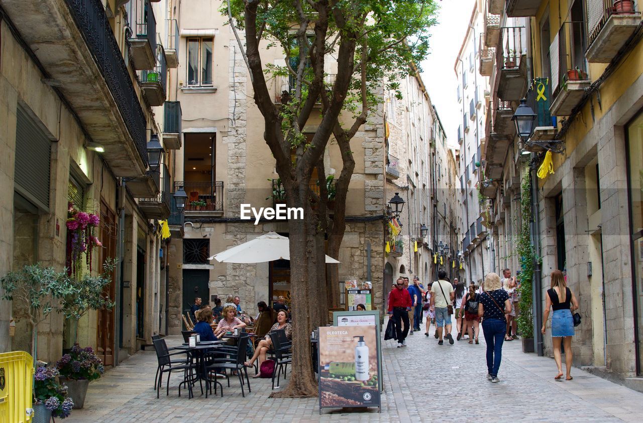 People on street amidst buildings in city