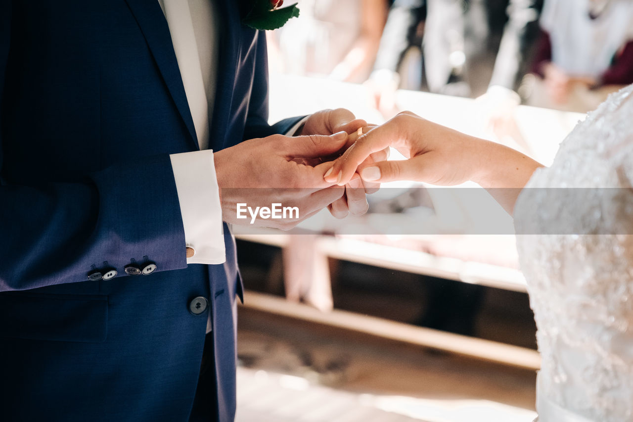 Midsection of couple wearing ring