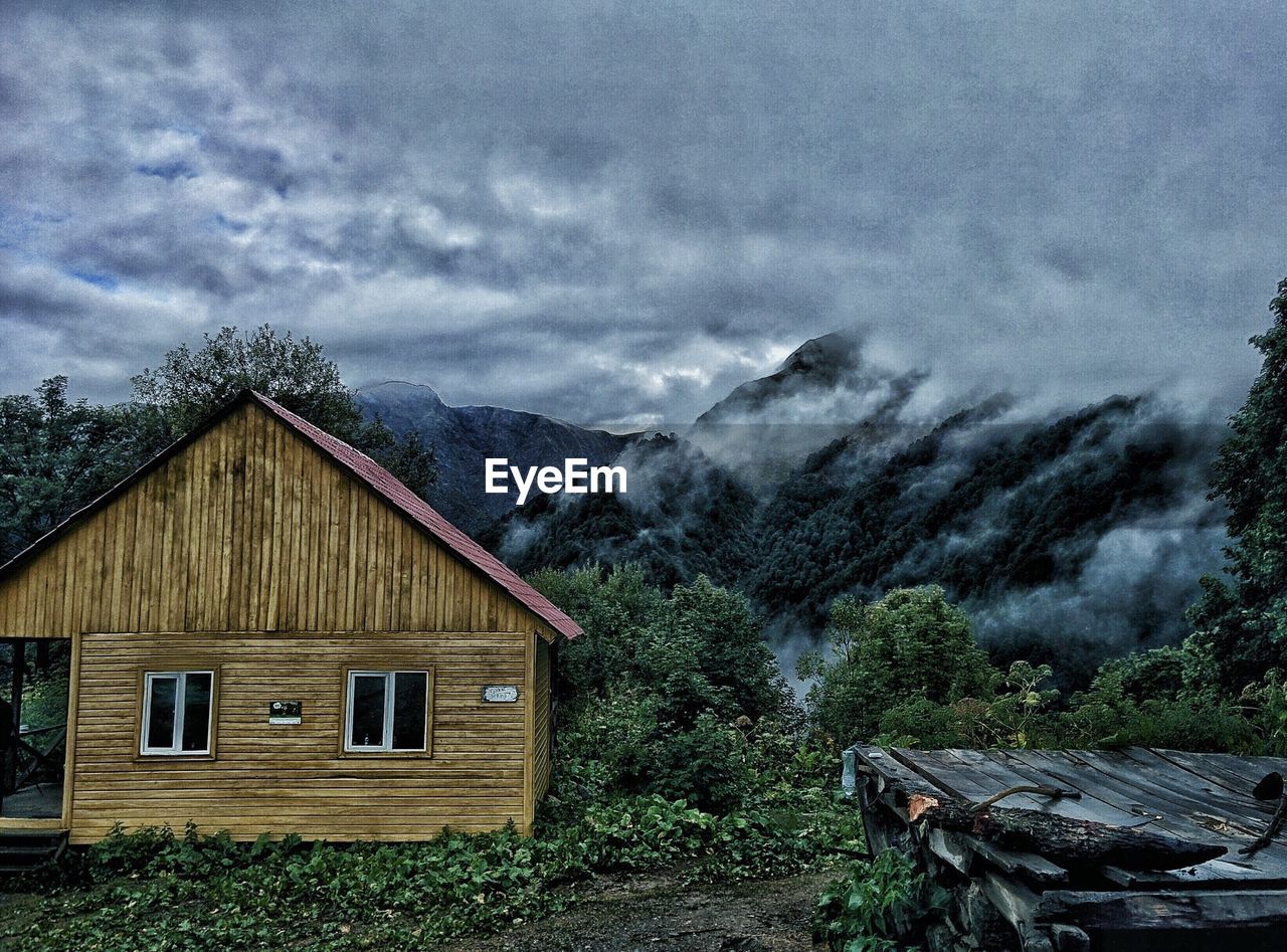 HOUSES ON MOUNTAIN AGAINST SKY