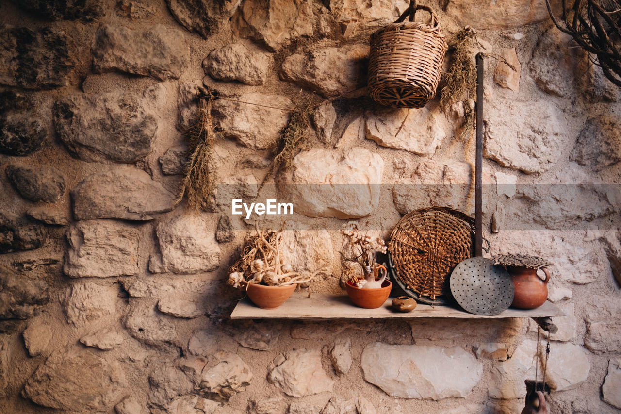 LOW ANGLE VIEW OF OLD STONE WALL HANGING BY BRICK WALLS