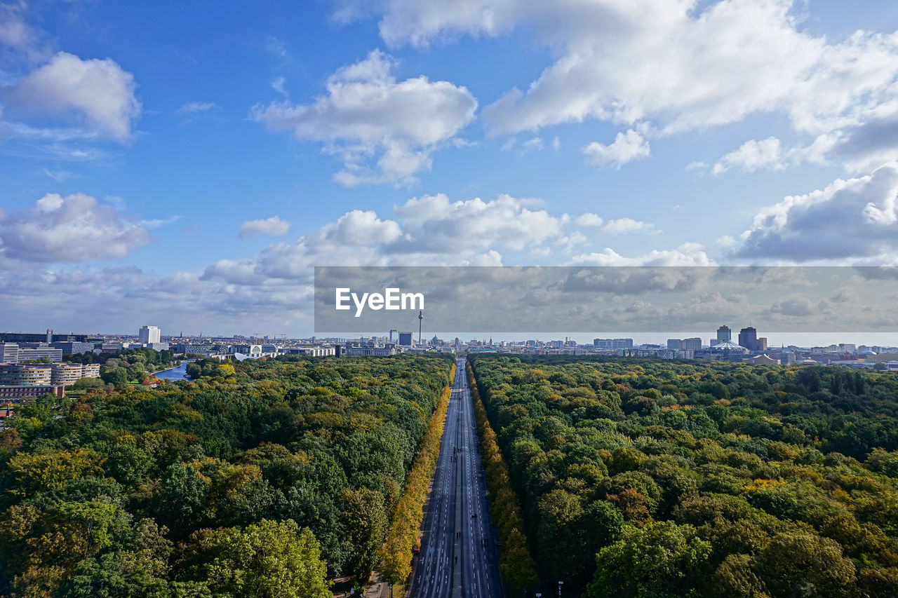 Panoramic shot of road amidst plants and trees against sky