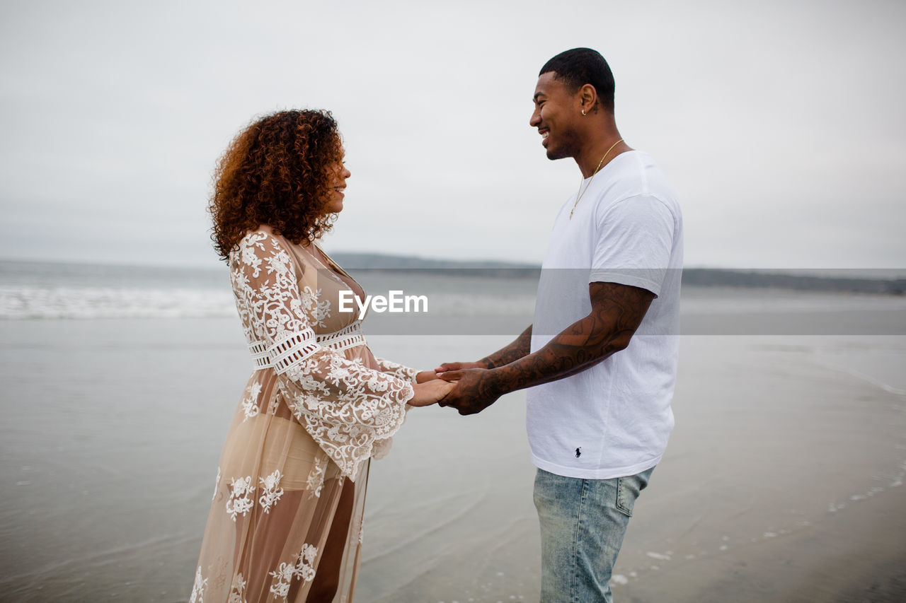 Mixed race couple holding hands on beach