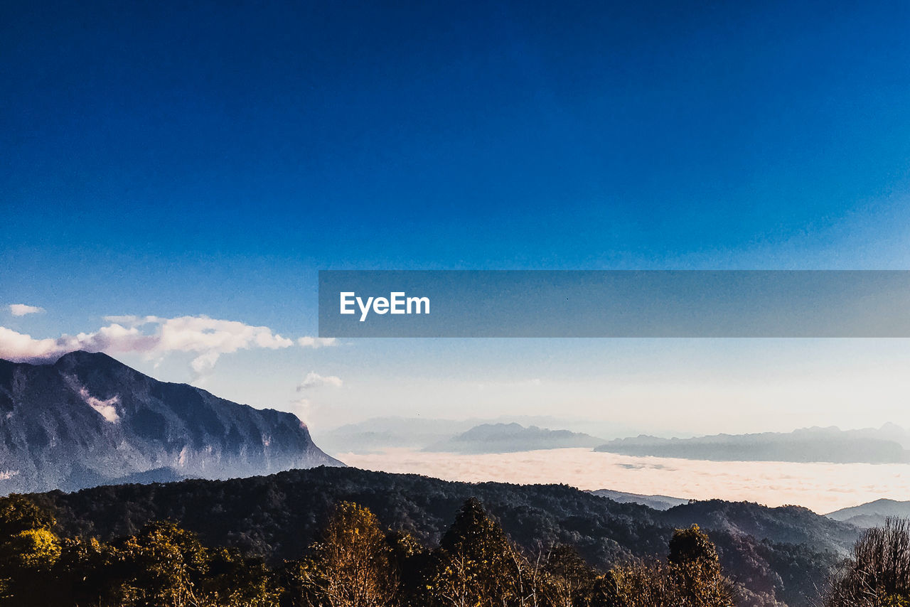 Scenic view of mountains against blue sky