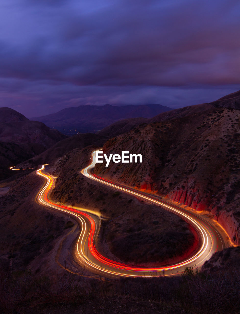 Aerial view of illuminated mountain road against sky at night