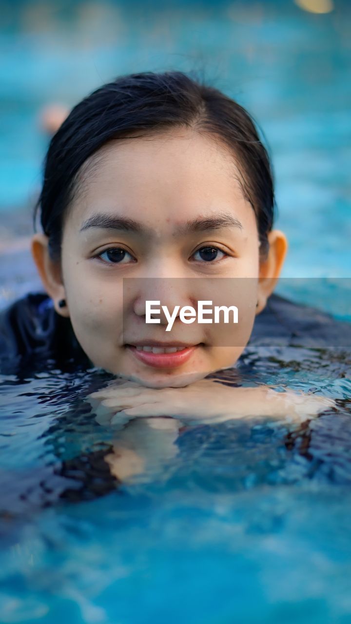 Portrait of young woman swimming in pool