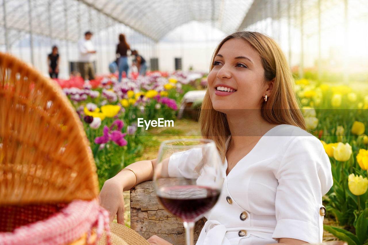 Relaxed young woman between flowers in picnic on spring time. selective focus.