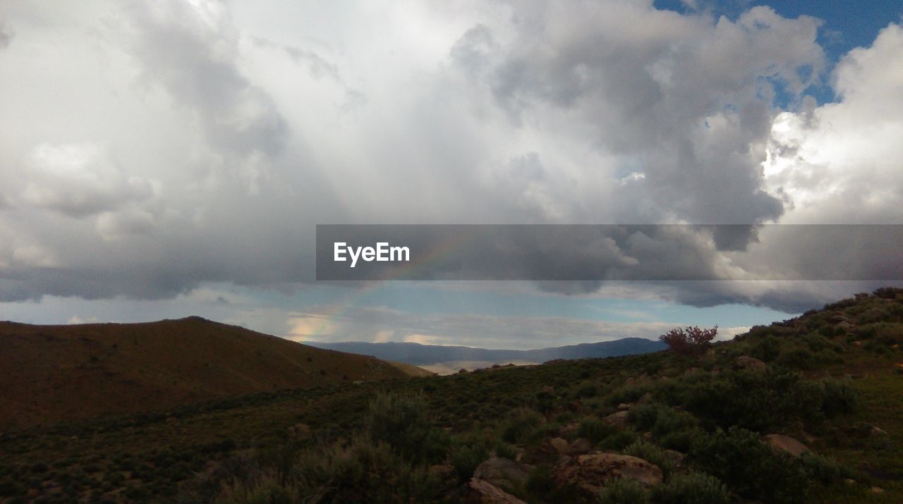 SCENIC VIEW OF LANDSCAPE AGAINST STORM CLOUDS