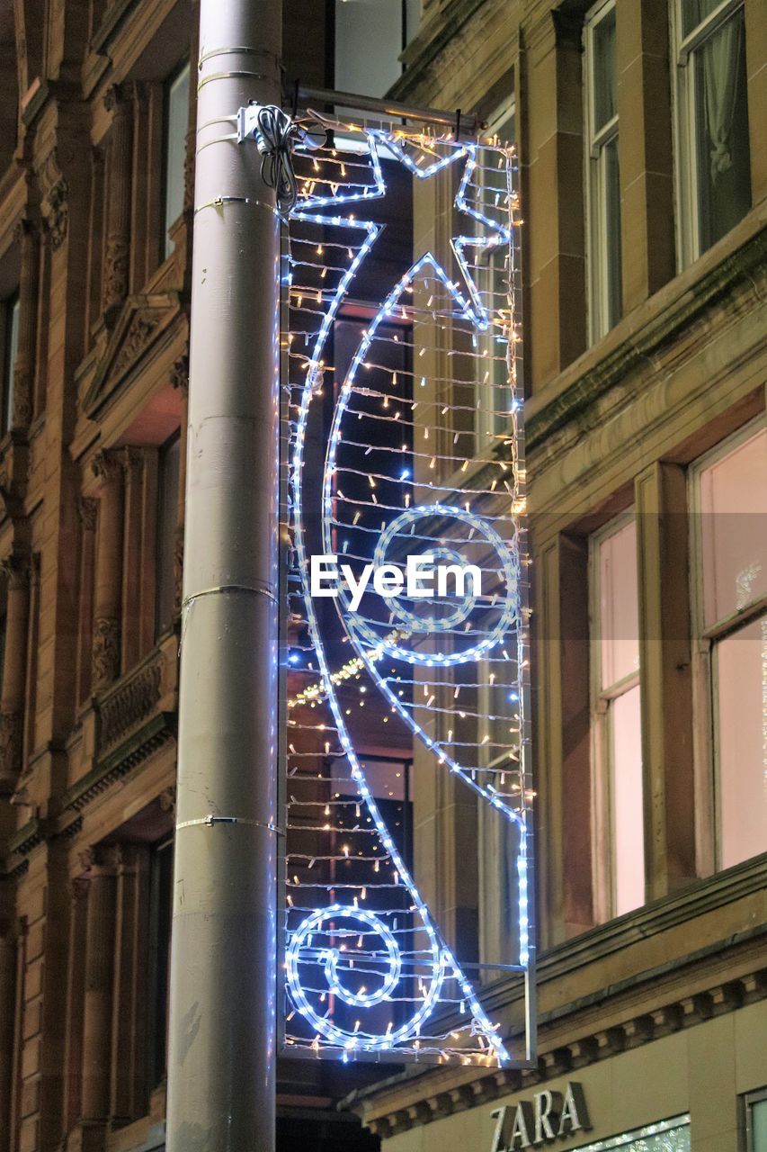 LOW ANGLE VIEW OF ILLUMINATED TEXT AT NIGHT