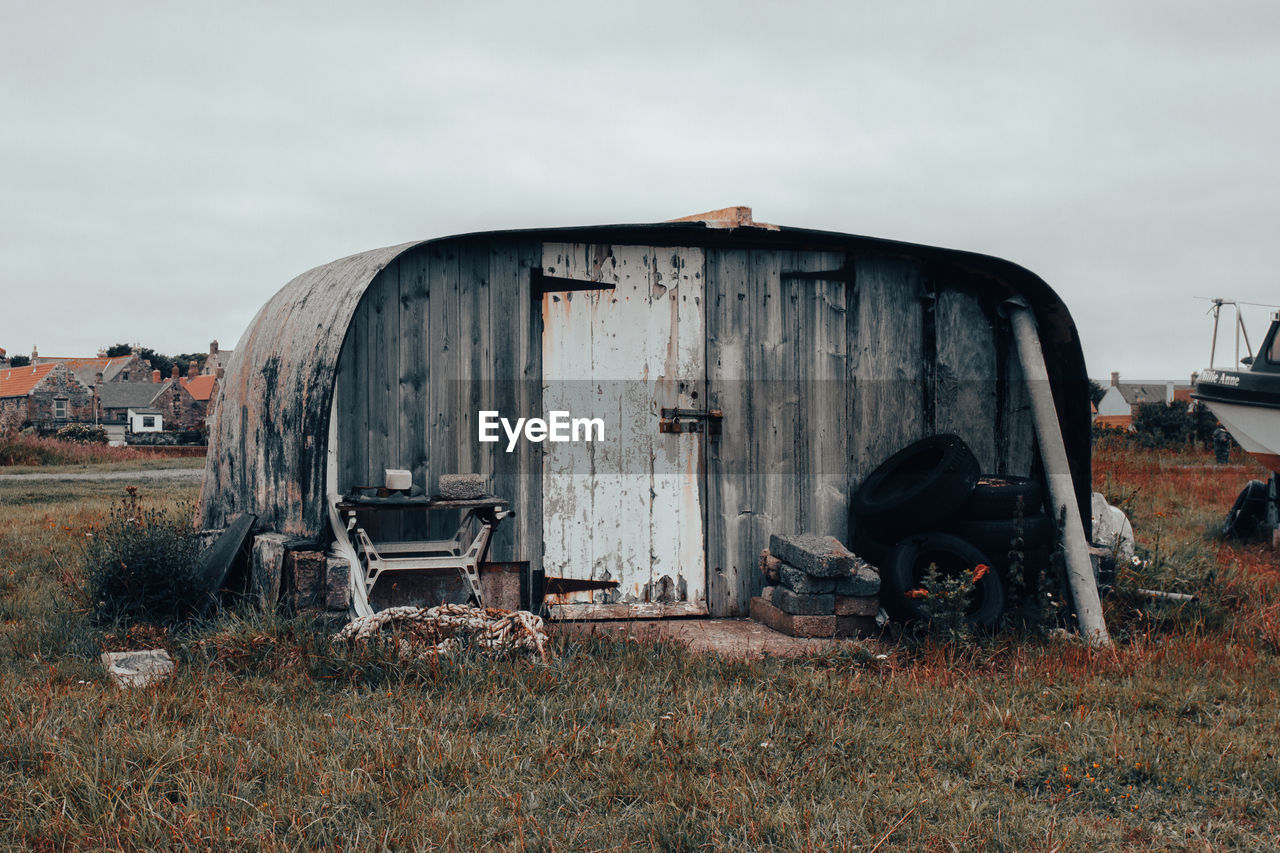 ABANDONED VEHICLE ON LAND AGAINST SKY