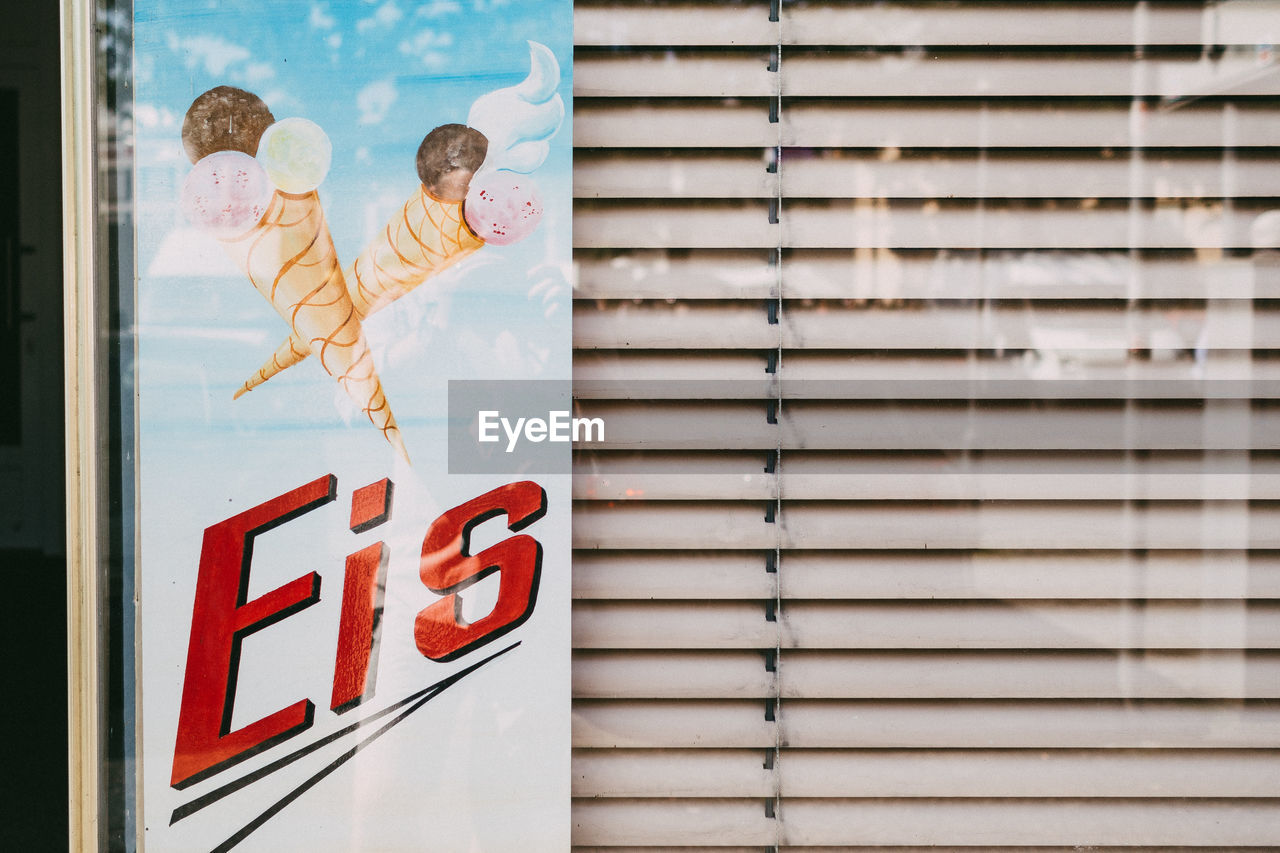 Close-up of information sign seen through glass window