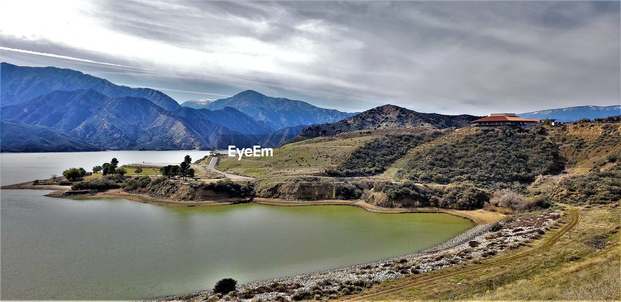 Scenic view of lake by mountains against sky