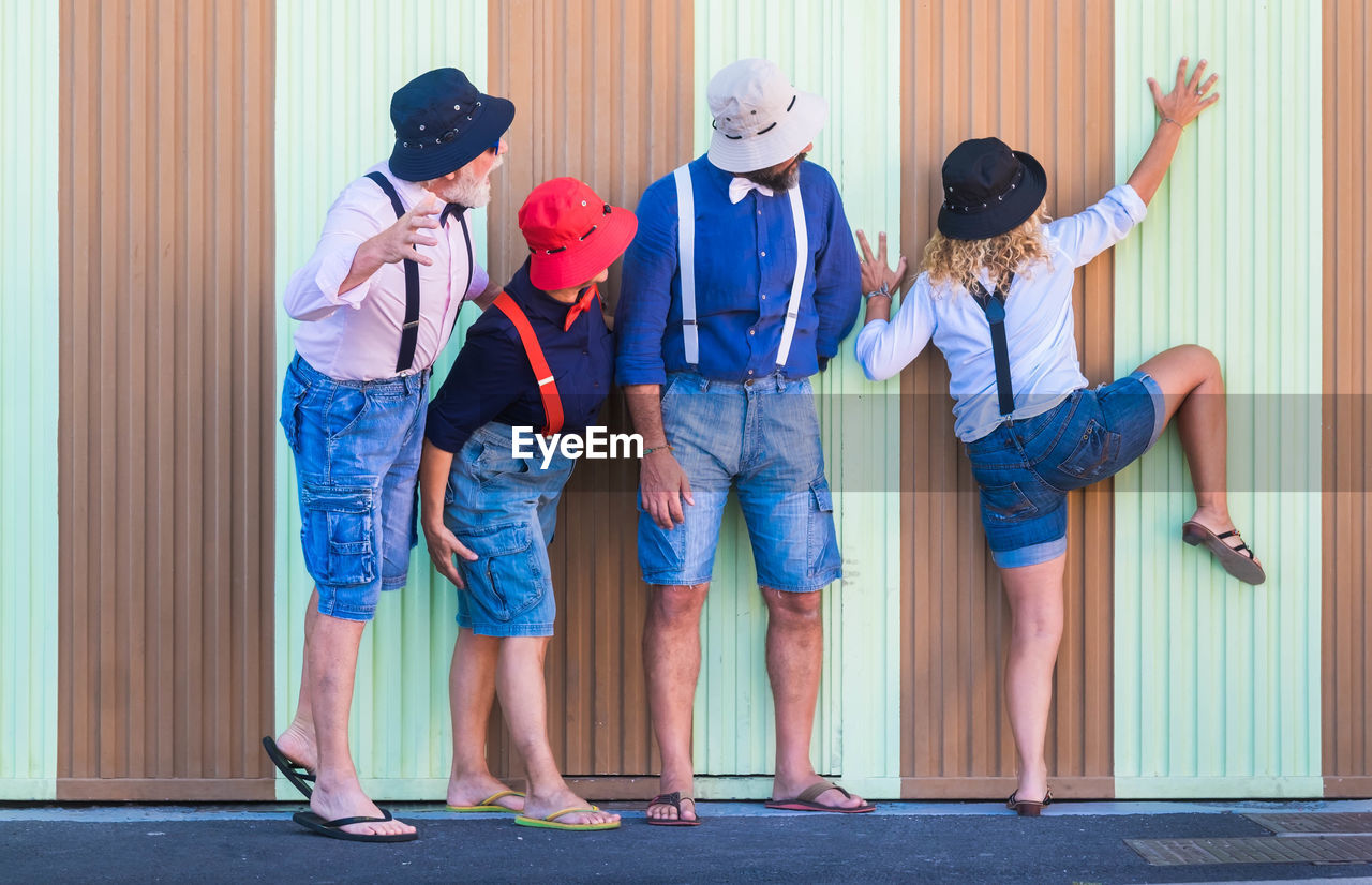 GROUP OF PEOPLE STANDING AGAINST WALL