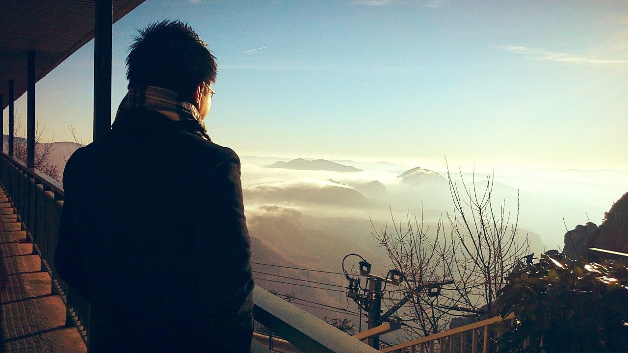 WOMAN STANDING ON MOUNTAIN AGAINST SKY