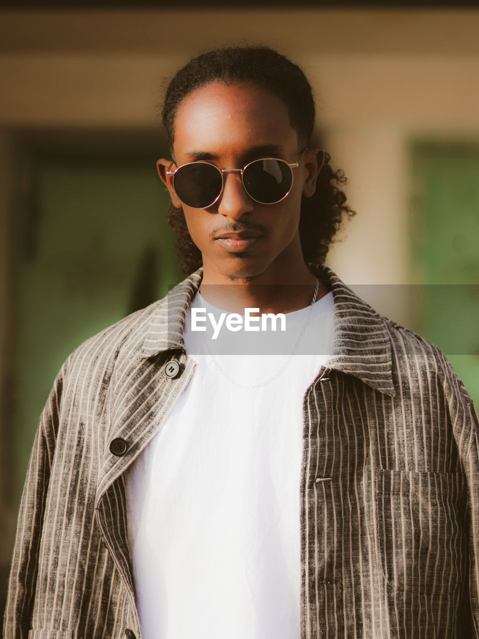 Portrait of young man wearing sunglasses standing outdoors