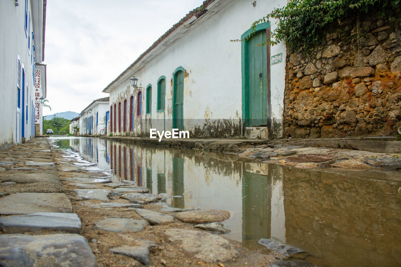 Reflection of old houses in a puddle after rain.