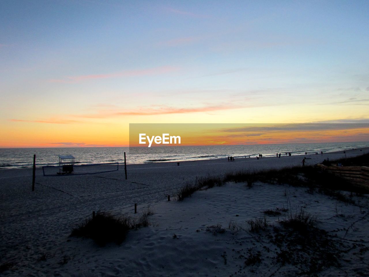 SCENIC VIEW OF BEACH AGAINST SKY AT SUNSET