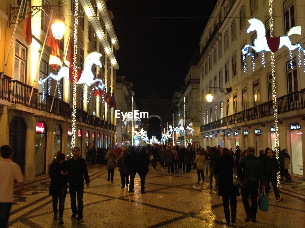 PEOPLE AT ILLUMINATED CHRISTMAS TREE AT NIGHT