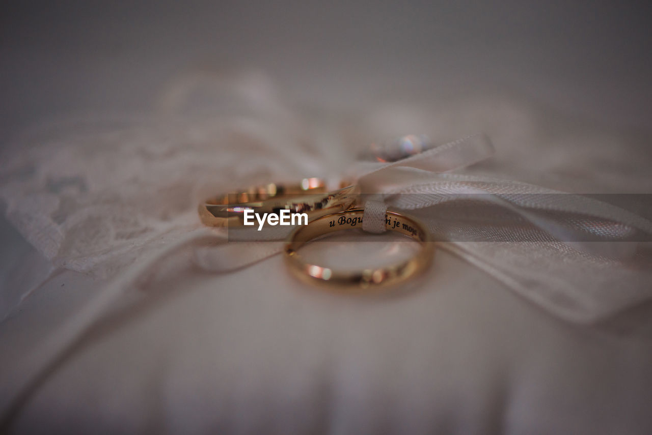 Close-up of wedding rings on bed