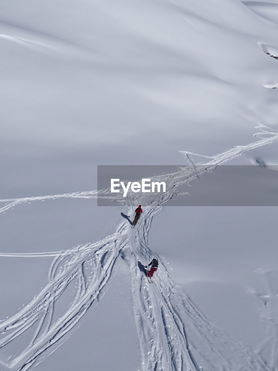 High angle view of people skiing on snow covered field