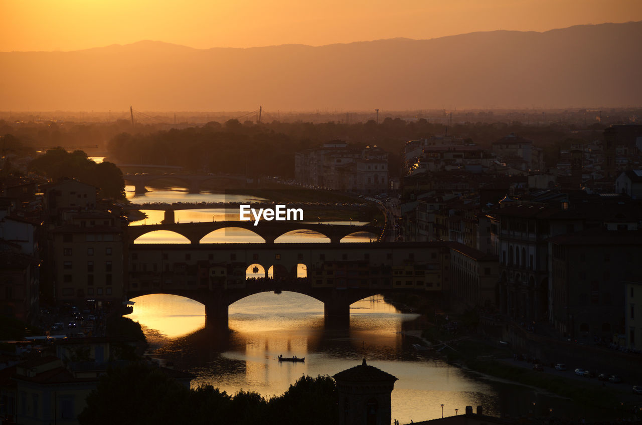 High angle view of bridges over river in city during sunset