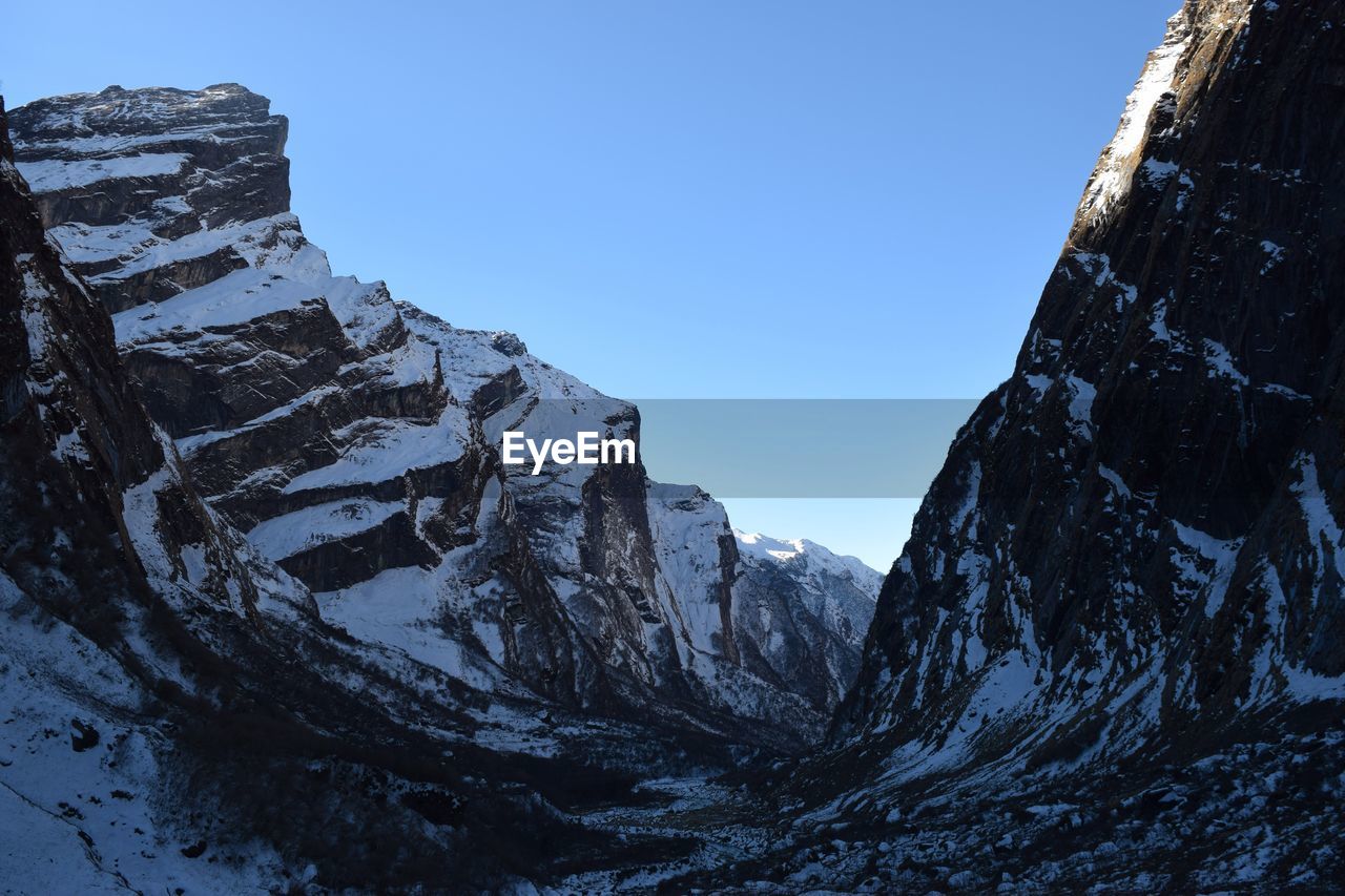 Low angle view of rocky mountains against sky