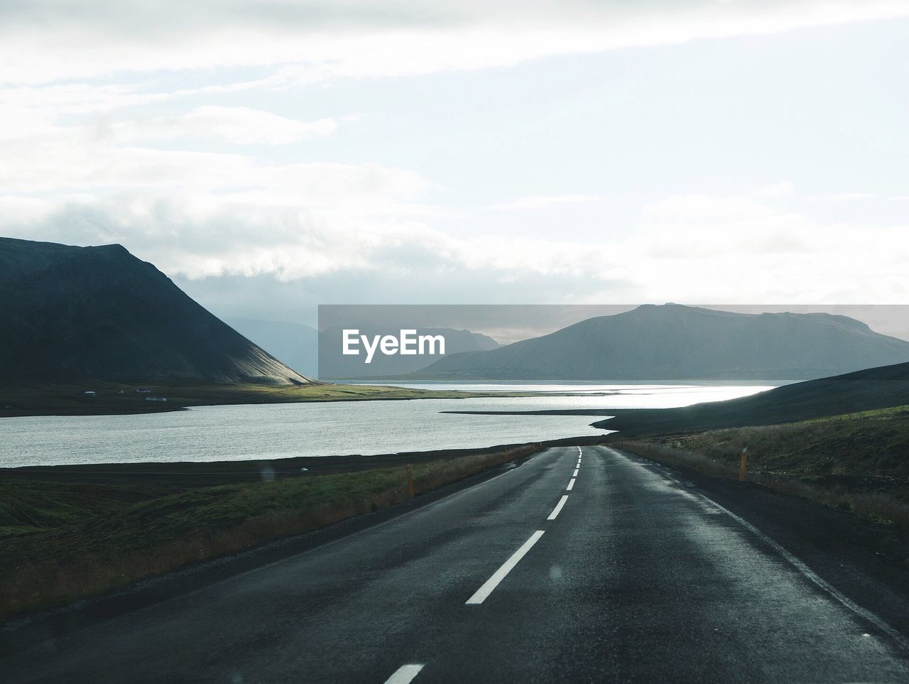 ROAD AMIDST MOUNTAINS AGAINST SKY