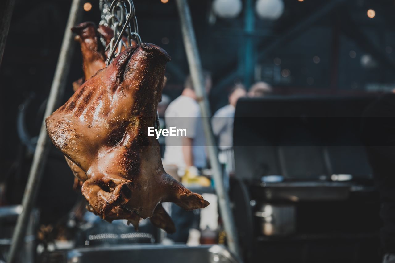 Close-up of roasted meat hanging in kitchen