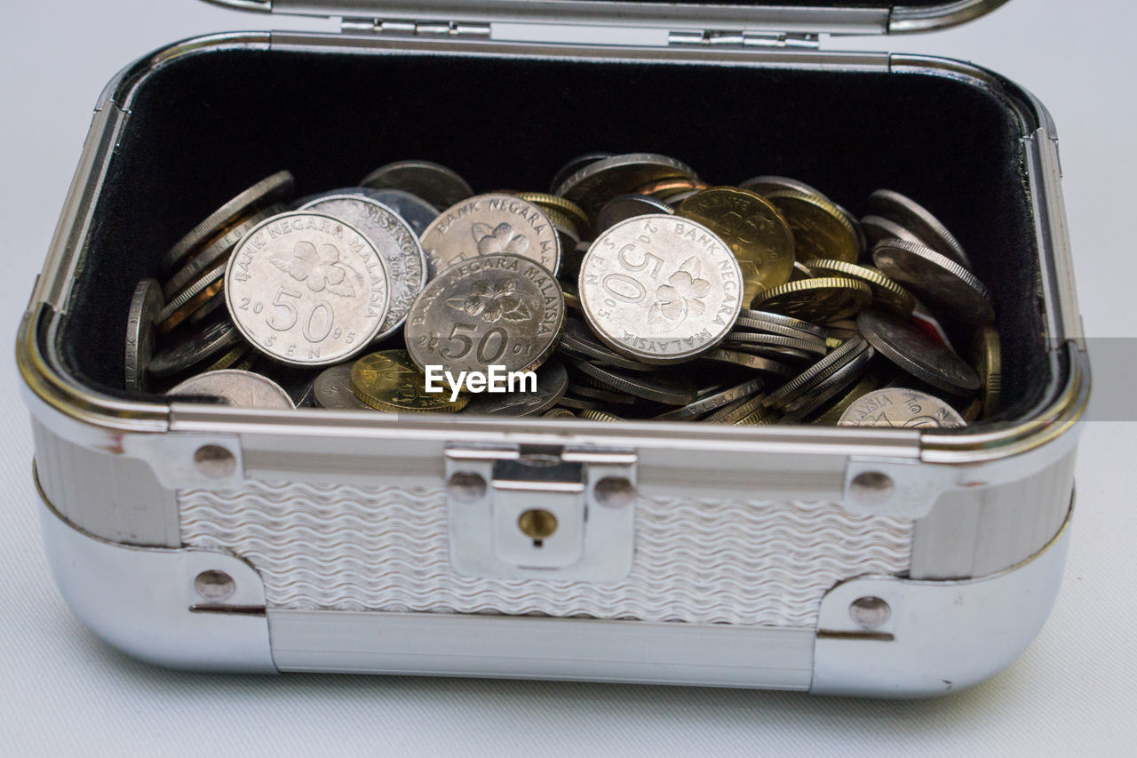 High angle view of coins in box over white background