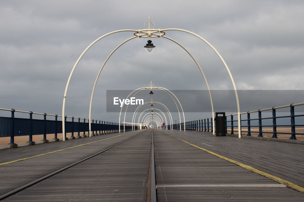 View of southport pier tramway against cloudy sky