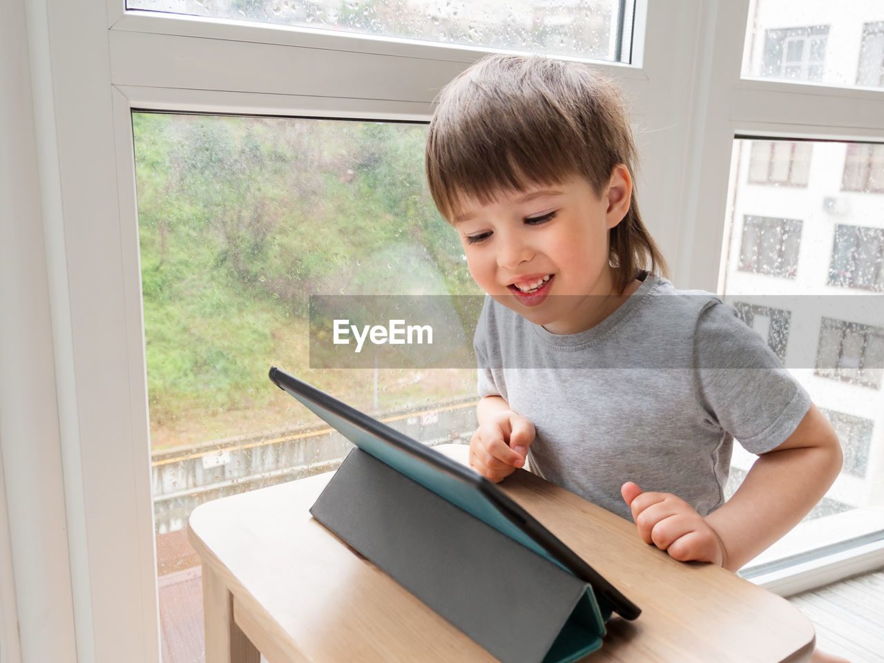 Curious boy watch cartoons on digital tablet. kid uses electronic device for call via internet. 