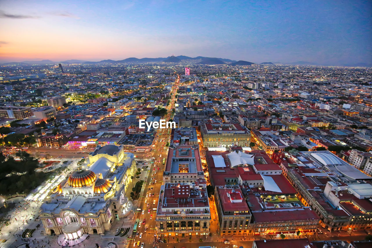 HIGH ANGLE VIEW OF ILLUMINATED BUILDINGS IN CITY
