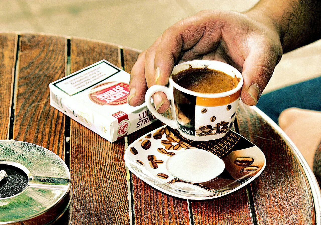 CLOSE-UP OF COFFEE CUP WITH COFFEE CUP ON TABLE