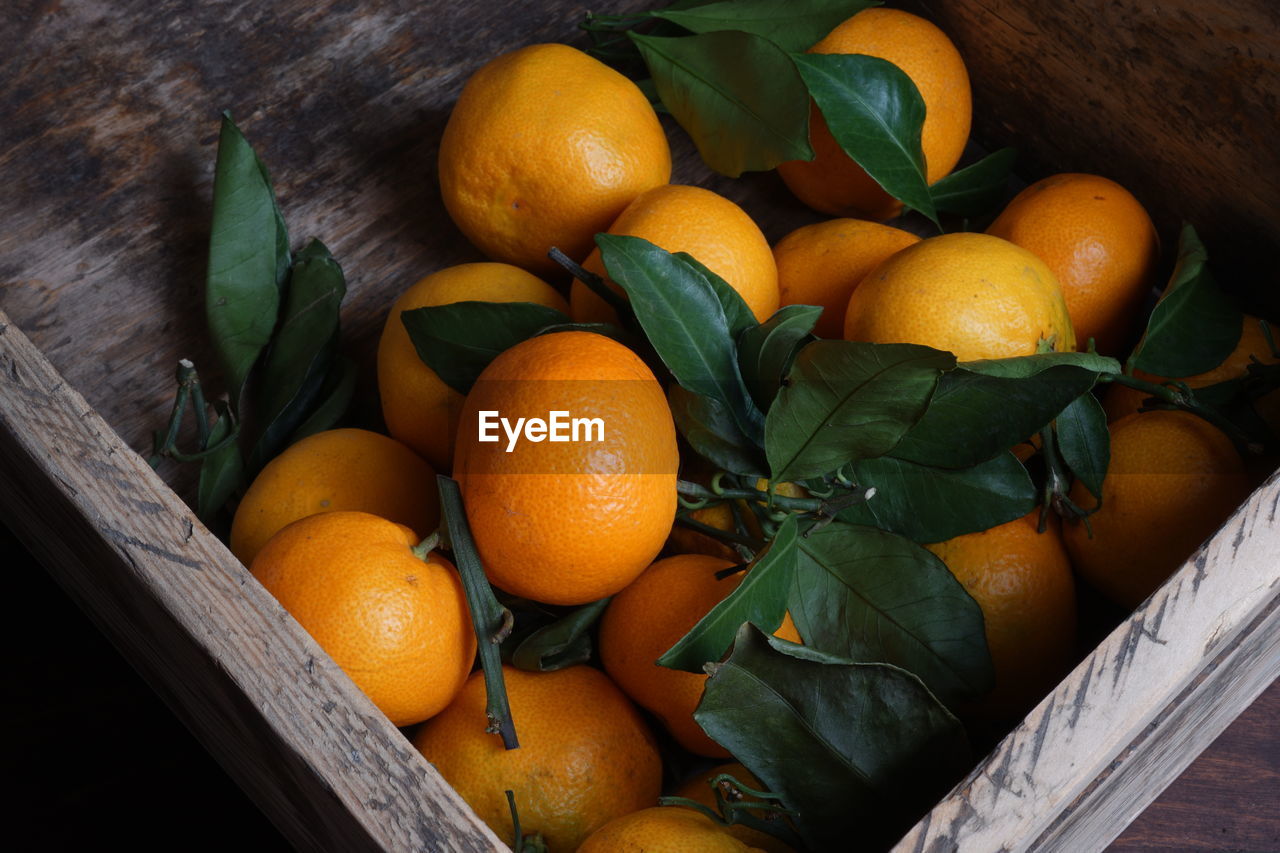 High angle view of mandarins and fruits on wood