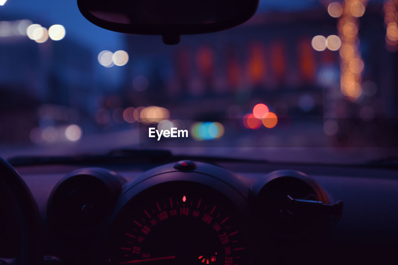 View of illuminated city seen from inside of the car at night